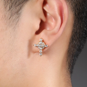 Close-up of golden snowflake cross magnetic earring with white cubic zirconia stones