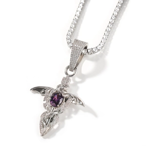 Detailed macro view of hip-hop bat wings cross pendant with purple oval zircon stone