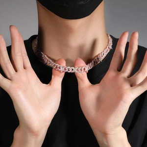 Detail view of 10mm pink gold Cuban chain necklace with micro-pave stones on a model