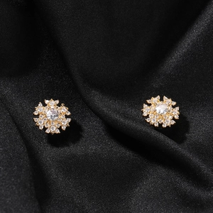 Detailed macro view of 8mm snowflake magnetic earrings with sparkling cubic zirconia crystals