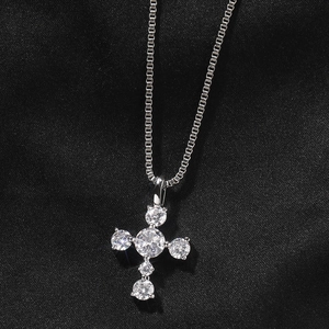 Macro detail of S925 silver cross pendant with clear cubic zirconia on black velvet