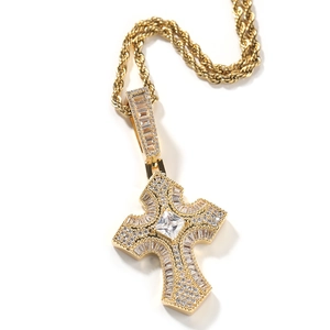 Primer plano del colgante de cruz hip hop dorado con circonitas y cadena de cordón