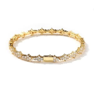 Dettaglio di un bracciale tennis placcato oro con diamanti a stella e chiusura a cassetta