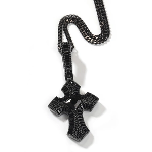 Detalle de collar con colgante de cruz negra y circonitas cúbicas con cadena de eslabones
