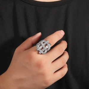 Macro detail of a silver hip hop ring featuring a dollar sign iced out with cubic zirconia