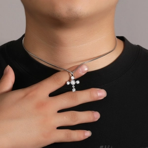 Close-up of a men's S925 silver cross pendant with sparkling zircon on a black t-shirt