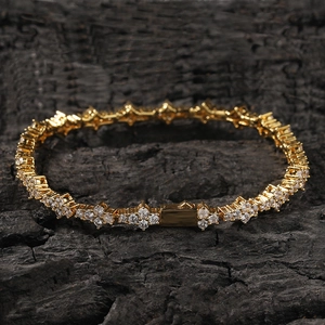 Dettaglio macro di un bracciale hip-hop dorato con maglie floreali e zirconi chiari