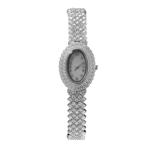Gros plan d'une montre ovale pour femme avec zircons sertis et cadran en nacre blanche