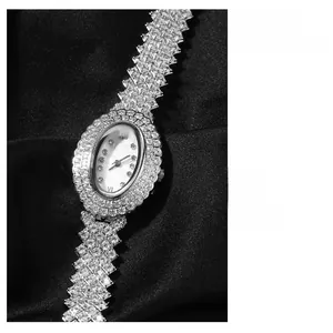 Détail macro d'une montre à quartz ovale avec pavé de diamants sur fond de soie noire