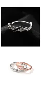 Detailed view of silver and rose gold lightning rings with micro-paved cubic zirconia