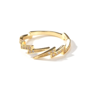 Macro detail of lightning shaped gold ring with sparkling zircon inlays and shiny finish