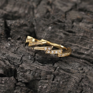 Macro shot of double lightning bolt ring with sparkling pavé zircons on wood
