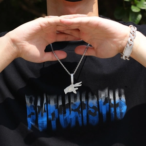 Detail of hip hop hand gesture pendant and cuban link bracelet with sparkling zircons