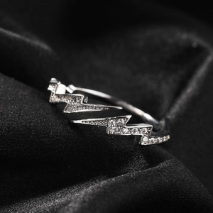 Macro shot of silver hip hop lightning ring with pave-set cubic zirconia on black silk