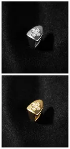 Macro detail van gouden en zilveren kruis tandjuwelen met micro-pave zirkonia steentjes