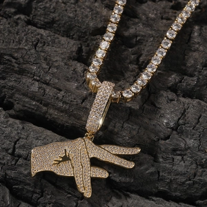 Macro detail of gold hip hop pendant with cubic zirconia on black wood background