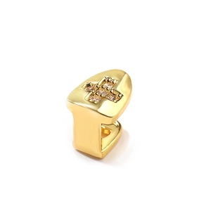 Macro detail van vergulde enkele tand grillz met micro-pave zirkoon kruis ontwerp