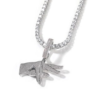 Macro detail of iced-out hip hop hand pendant with tennis chain in silver finish