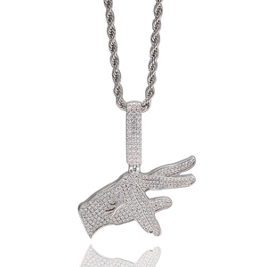 Macro detail of hip hop gesture pendant with micro-paved zircons on silver rope chain