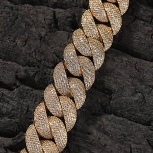 Macro shot of gold-plated Cuban link chain with detailed cubic zirconia inlay work