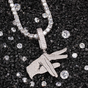Macro shot of hip-hop hand gesture pendant with sparkling zircons on tennis chain
