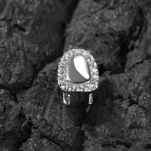 Macro shot of silver hip-hop grillz with zircon stones on a charcoal background