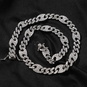 Detail of silver hip hop chain with iced out cubic zirconia on black silk background