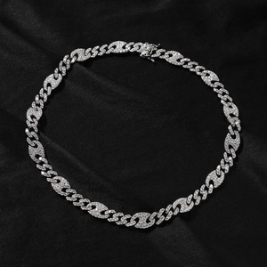 Macro detail of iced out silver pig nose Cuban link chain with paved white zircons on black silk