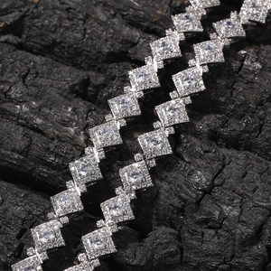 Macro shot of iced out diamond rhombus chain necklace on textured charcoal background