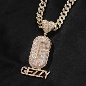 Vue macro du pendentif personnalisé C GEZZY avec zircons incrustés et chaîne cubaine dorée