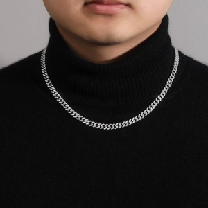 Close-up of a 925 silver 6mm Cuban link necklace with iced out moissanite on a black shirt