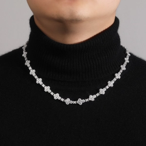 Detail shot of iced-out clover link necklace worn on model for a hip hop luxury aesthetic