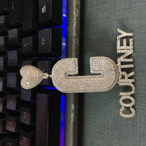 Détail du collier hip hop argenté avec plaque Courtney et pendentif lettre C sertis