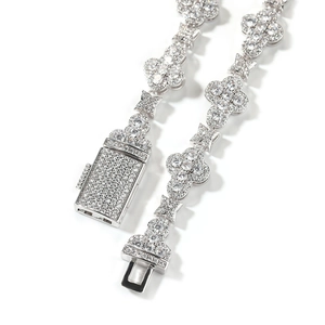Macro view of micro-pave encrusted cross flower links and buckle on a silver chain