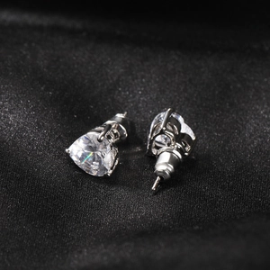 Gros plan de boucles d'oreilles en zircone coeur avec serti classique à trois griffes