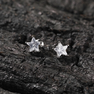 Vue rapprochée de boucles d'oreilles étoiles en argent avec zircon sur bois sombre