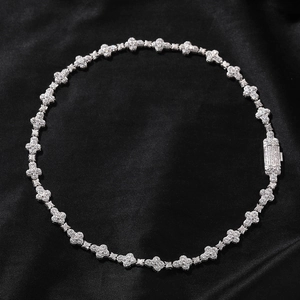 Macro shot of silver clover chain links fully paved with crystals on black silk fabric