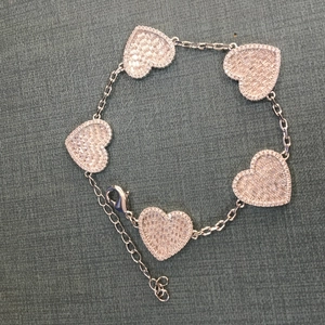 Dettaglio del bracciale cuore argento con cinque ciondoli in zircone e moschettone