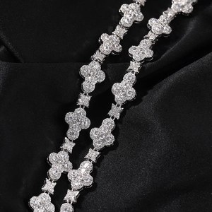 Macro shot of silver hip-hop necklace with 10mm iced-out diamond clover links on black silk