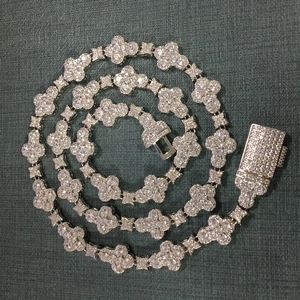 Macro detail of silver floral links with micro-pave crystals on a 10mm hip-hop chain