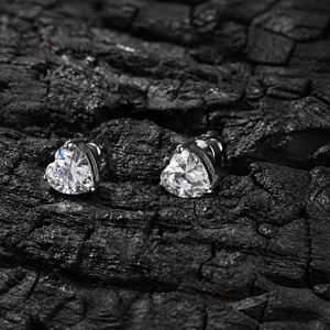Vue macro détaillée de boucles d'oreilles en zircon en forme de cœur sur fond sombre