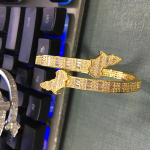 Detail eines vergoldeten offenen Armbands mit Zirkonia-Mikropavé und Kartenmotiv