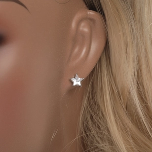 Clou d'oreille en forme d'étoile argentée avec cristal de zircone sur l'oreille