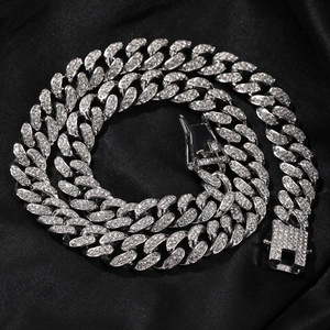 Détails macro d'une chaîne cubaine de 12mm sertie de diamants sur fond de satin noir chic