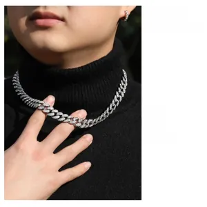 Chaîne cubaine argentée avec zircons et boucles d'oreilles portées par un mannequin