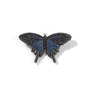 Makroaufnahme von Schmetterlingsanhänger mit blauen Zirkonia auf schwarzem Metallfinish
