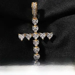 Vue macro d'un pendentif croix en cœur et zircon sur un tissu noir texturé