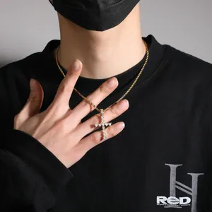 Gros plan d'un collier chaîne torsadée dorée avec pendentif croix en zircon sur un mannequin