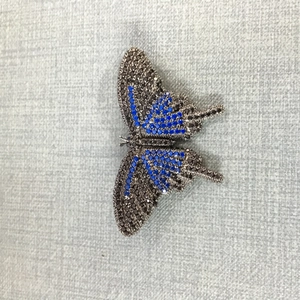 Detailansicht des Schmetterlingsanhängers mit blau-schwarzen Zirkoniasteinen besetzt