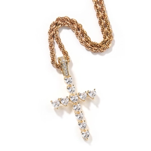 Détail macro du collier pendentif croix doré avec zircons en cœur et chaîne de type corde